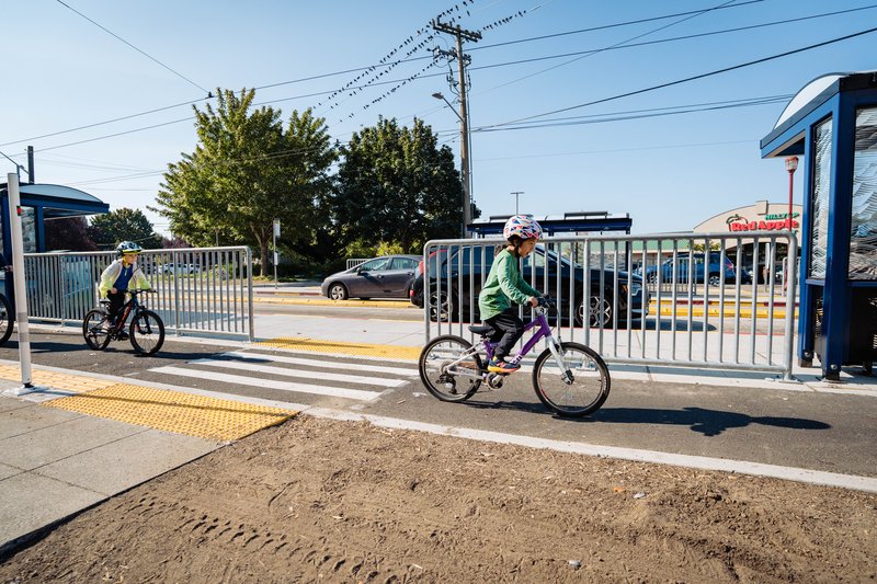 Kid Biking Safely on Beacon Ave with Multimodal Infrastructure in the Background