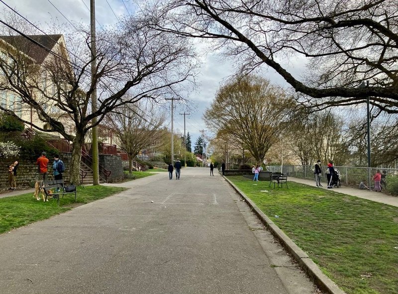 The pedestrian-only Franklin Ave School Street, next to Tops K-8 in Eastlake, with people walking in the street and hanging out on the sidewalk.