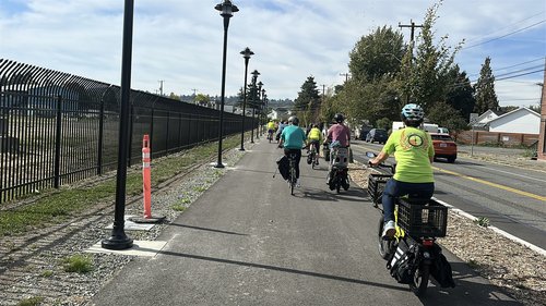Many people riding bikes on the new Georgetown to South Park Trail. This section is a wide walking and biking path along Ellis St in Georgetown.