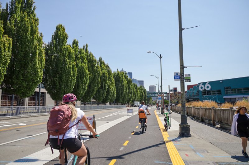 Two people riding bicyles on new bike path near Pier 66